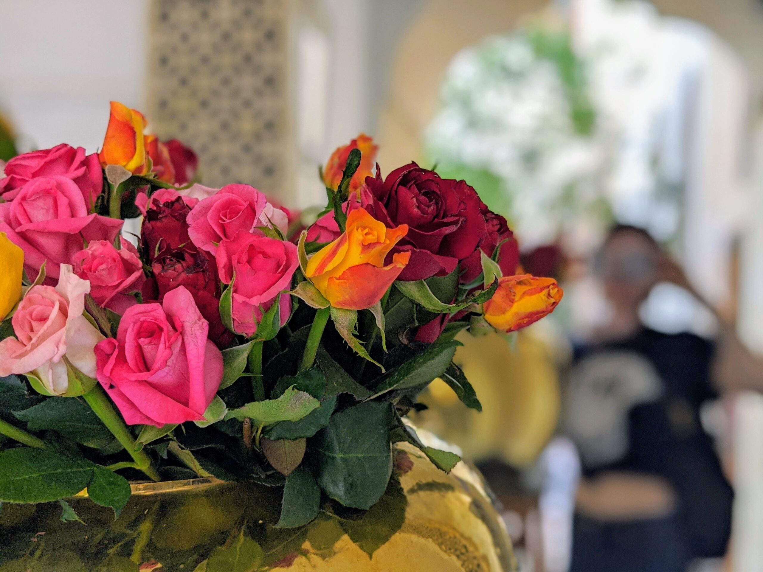 A vase of budding roses in an assortment of colors